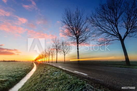 Picture of A sunrise on a rural road cars passing by